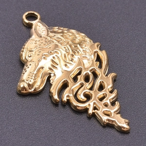 Detailed close-up of a 18k gold-plated stainless steel wolf head pendant with carvings