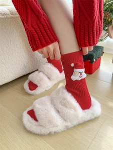 Close-up of cute Santa Claus embroidered socks and plush slippers for Christmas