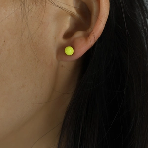 Minimalist neon yellow round stud earrings shown on model for a trendy ear jewelry style