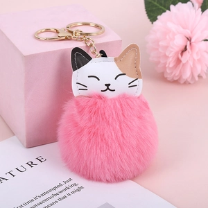 Close-up of pink faux rabbit fur pompom keychain with cat leather detail on a pink base