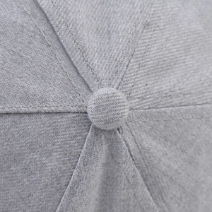 Close-up of light gray baseball cap crown with twill texture and fabric top button