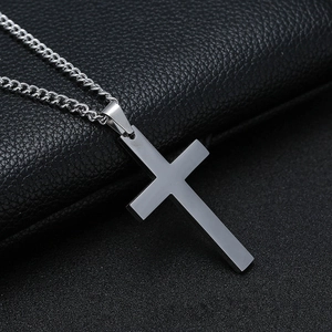 Collar con colgante de cruz de metal negro minimalista y cadena sobre fondo de cuero