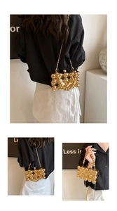Detail of gold acrylic egg bag with spherical metal clasp and elegant chain strap
