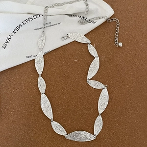 Detailed macro view of vintage silver leaf-shaped chain links with textured metal surface