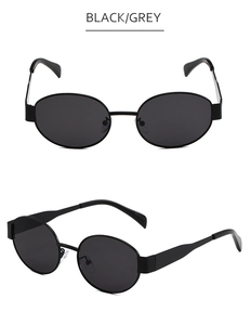 Detail view of oval metal sunglasses featuring black frames and grey lenses in a retro style