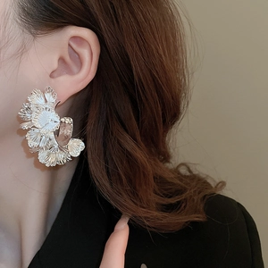 Gros plan détaillé de boucles d'oreilles à pétales de fleurs portées à l'oreille