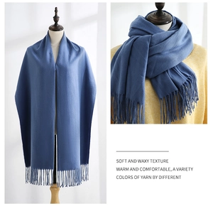 Detail of dark blue cashmere-style scarf with long tassels and soft woven texture