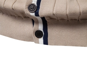 Dettaglio cardigan in maglia kaki con abbottonatura a righe blu navy e bottoni scuri