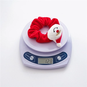 Detailed view of red velvet Christmas Santa scrunchie weighing 12.8g on a digital scale