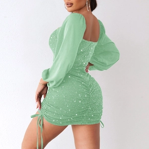 Close-up of light green bodycon dress featuring shimmering fabric and side drawstring detail