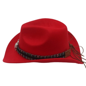 Détail d'un chapeau de cow-boy rouge avec bande géométrique et emblème de tête de taureau