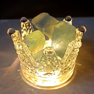Illuminated glass crown jar filled with green fluorite stones for bedroom aromatherapy