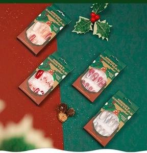 Detailed view of Christmas press-on nails set featuring glitter flakes and holiday motifs