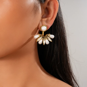 Gros plan de boucles d'oreilles baroques en éventail avec perles et cristaux sur mannequin