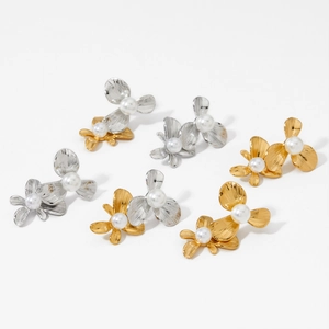 Elegant gold and silver floral stud earrings with pearl centers set on white background