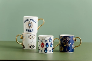 Detailed view of four Nordic ceramic mugs with gold handles and Hamsa Hand patterns