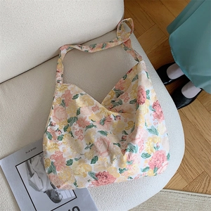 Detailed texture of floral canvas tote bag showing high-quality fabric on beige sofa