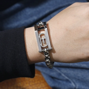 Macro view of men's silver chain bracelet featuring a hollow rectangle cross charm