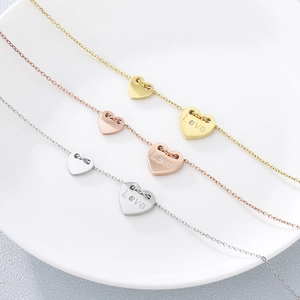 Drei Herzanhänger in Gold, Roségold und Silber mit Love-Gravur und einzelnem Diamanten