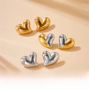 Detailed view of heart-shaped earrings in gold, silver, and dual-tone polished finishes