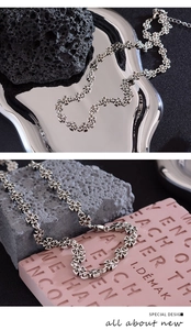 Detailed view of silver cross-shaped metal links on textured black and pink backdrops