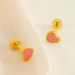 Détail de boucles d'oreilles cœur rose avec texture à pois et fermoir à vis sécurisé