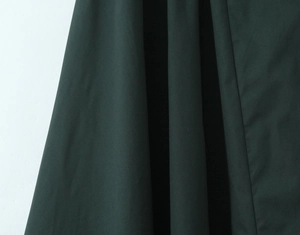 Close-up of dark green cotton linen fabric texture with natural drape and subtle sheen