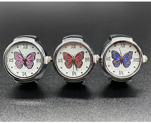 Macro detail of three silver ring watches with butterfly motifs and Roman numerals