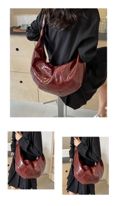 Detailed stitching and pleated texture of dark red leather croissant shoulder bag
