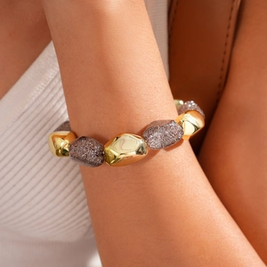 Detail of bohemian elastic bracelet with gold and translucent amber beads on wrist