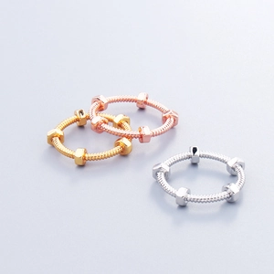 Detailed close-up of screw-style nut rings in gold, rose gold, and silver finishes