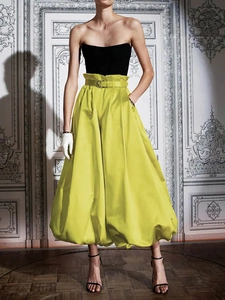 Haut tube noir élégant avec jupe midi évasée en satin jaune citron et ceinture assortie