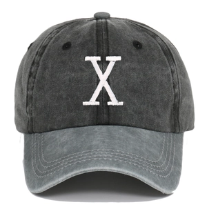 Close-up of embroidered white letter X on vintage washed cotton grey baseball cap