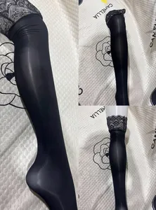 Detailansicht der schwarzen Halterlosen mit glänzendem Finish und floralem Spitzenbund