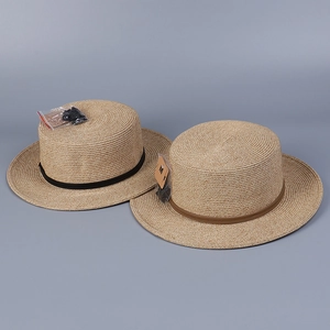 Gros plan de chapeaux canotiers en paille avec rubans décoratifs et cordons coupe-vent