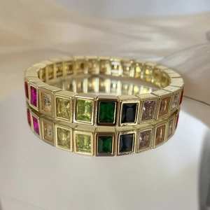 Detail view of rainbow crystal gold bracelet with rectangular cut stones on mirror