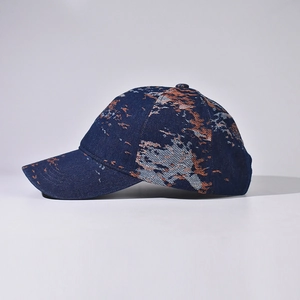 Detail of blue denim baseball cap featuring distressed vintage abstract embroidery