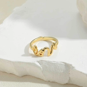 Macro shot of 14K gold-plated adjustable ring featuring stylized love letter design