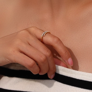 Close-up of gold-plated double-band cross ring with pave-set clear zircon on finger
