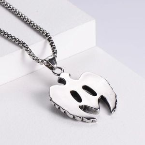 Retro titanium steel angel wing necklace with green zircon pendant on white stand