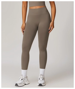 Detail of high-waist taupe yoga pants featuring seamless ribbed fabric and slim fit design