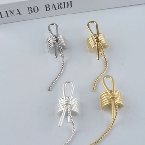 Minimalist knotted metal ear cuffs in gold and silver finishes with elegant tassels