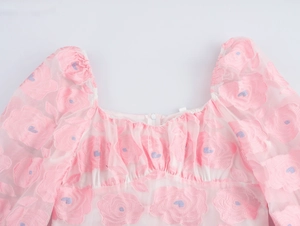Close-up of pink flower embroidery on a square neckline with puffy sleeve details