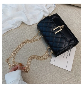 Close-up of black quilted chain bag featuring golden rectangle lock and luxury texture