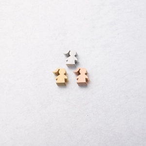 Detailed view of girl-shaped stainless steel charms in silver, gold, and rose gold finishes