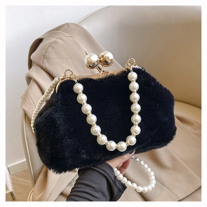 Detail of black plush handbag featuring golden frame and elegant pearl chain handle