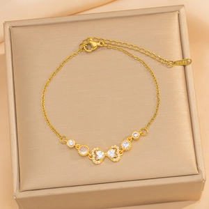 Gold plated stainless steel bracelet with bow design and inlaid zircons on a jewelry box