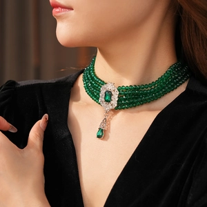 Detail of vintage choker featuring four layers of green faceted beads and emerald pendant