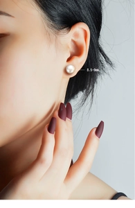 Macro shot of 8.5-9mm natural freshwater pearl earring worn on earlobe for size reference
