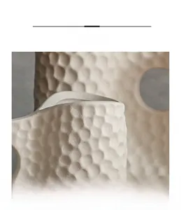 Vue macro détaillée du vase irrégulier en céramique montrant l'artisanat de texture alvéolée